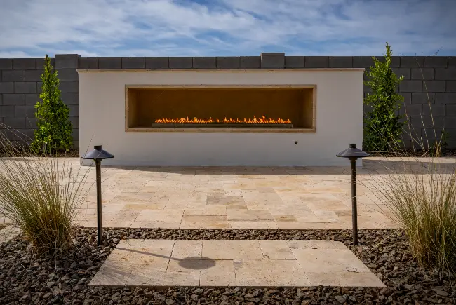 Custom built-in linear fireplace on a travertine patio