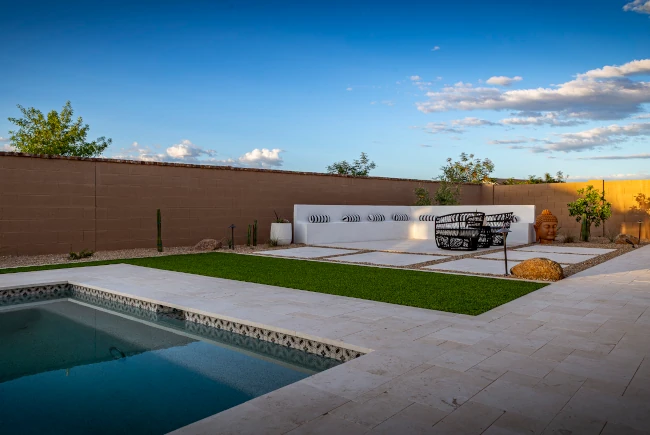 Travertine pool patio with decorative wall feature