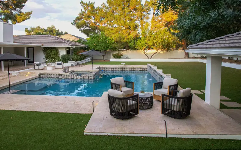 Travertine hardscape patio with pool and seating area