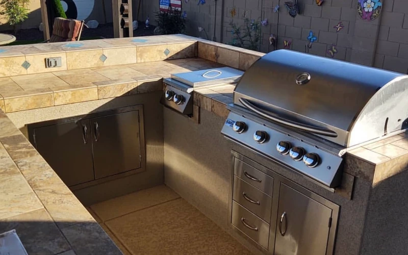 Outdoor kitchen island with built-in grill and storage