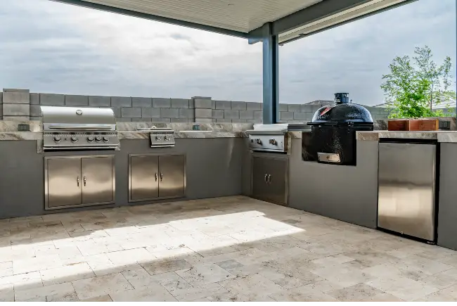 Custom outdoor kitchen with built-in grill and ceramic smoker