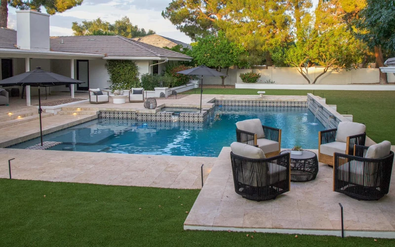 In-ground pool with covered patio and lounge seating
