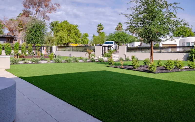Front yard artificial turf installation with desert landscaping